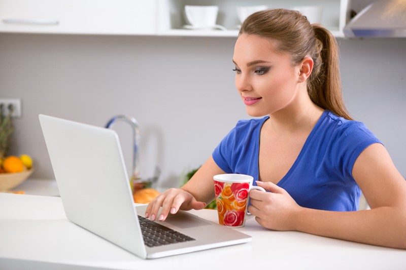 woman drinking tea on laptop
