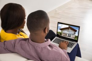 couple looking at house on laptop